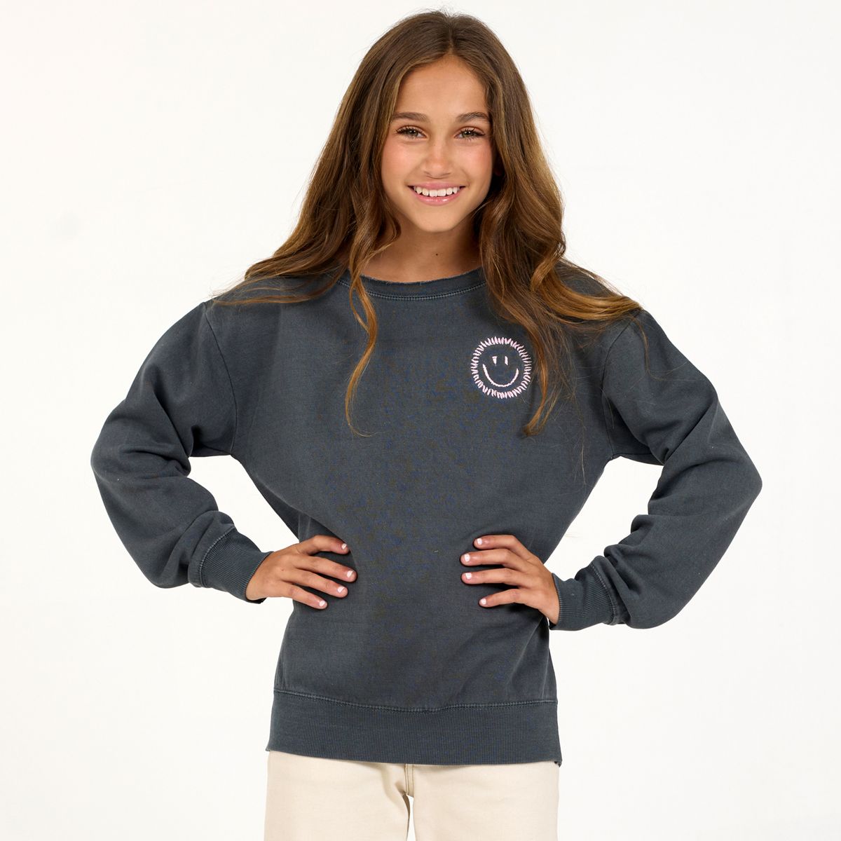 Girl wearing gray sweatshirt with smiley face