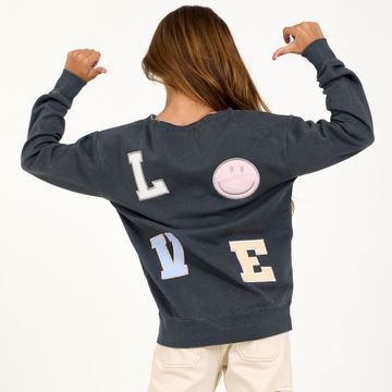 Girl wearing sweatshirt with LOVE patches