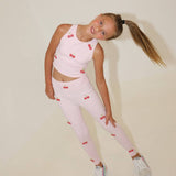 Young girl wearing a pink outfit with cherry patterns on a beige background