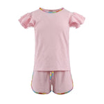 Pink children's outfit with gem rainbow trim on a white background