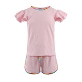 Pink children's outfit with gem rainbow trim on a white background