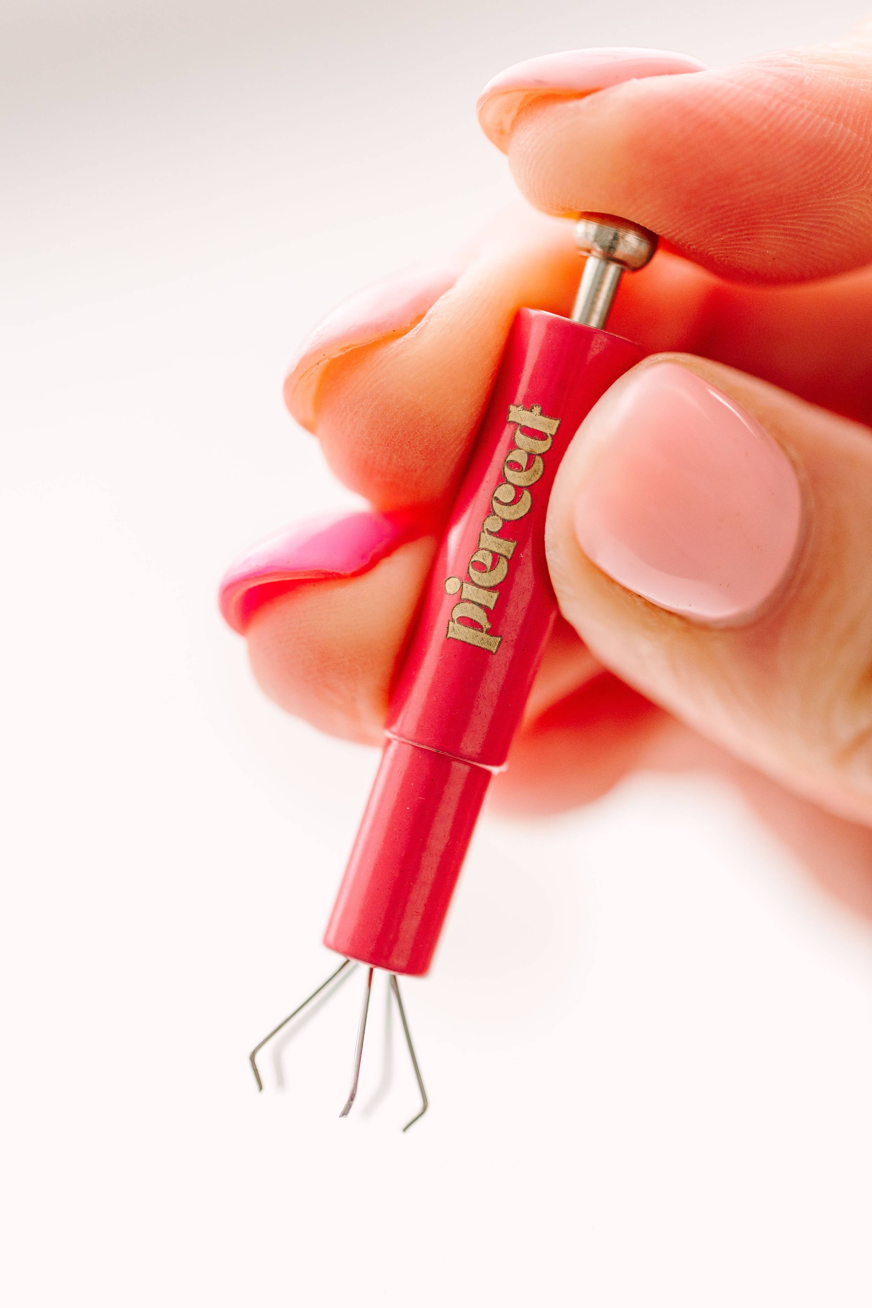 hand holding an earring back tool 
