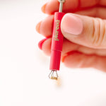 earring back tool held by a hand 
