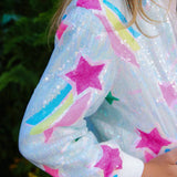 Sequined jacket with star and rainbow patterns worn by a person outdoors.