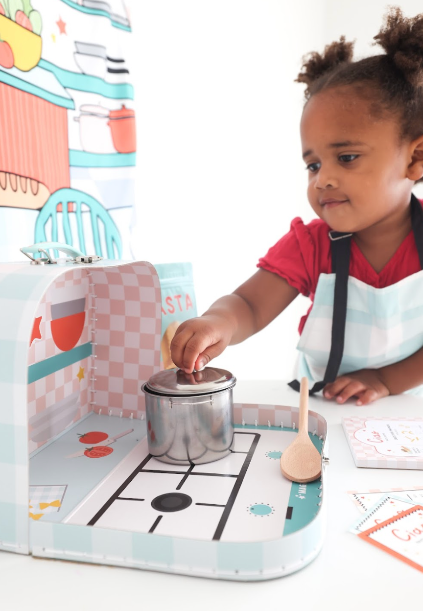 Girl playing with pasta kit