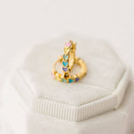 Gold earrings with colorful rainbow heart-shaped stones on a white background
