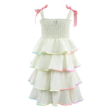 White tiered dress with colorful trim and pink straps on a white background