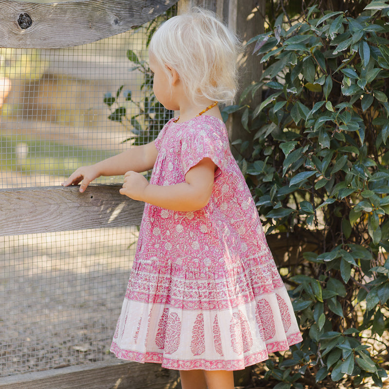 blonde toddler wearing pink block print dress 