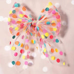 Colorful polka dot bow on a beige background