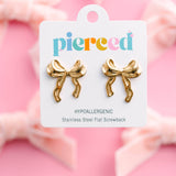 Gold bow-shaped earrings on a 'pierced' branded card against a pink background