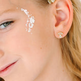 Close-up of a young girl wearing a gold mushroom earring with a winter mushroom design.
