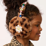 Child wearing a leopard print headband with decorative elements on a plain background