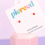 Earring display card with colorful 'pierceed' text and red earrings on a pink stand against a light purple background.