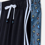 Black shorts with white drawstring and blue shorts with cartoon character pattern on a white background