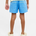 Person wearing blue shorts on a plain background