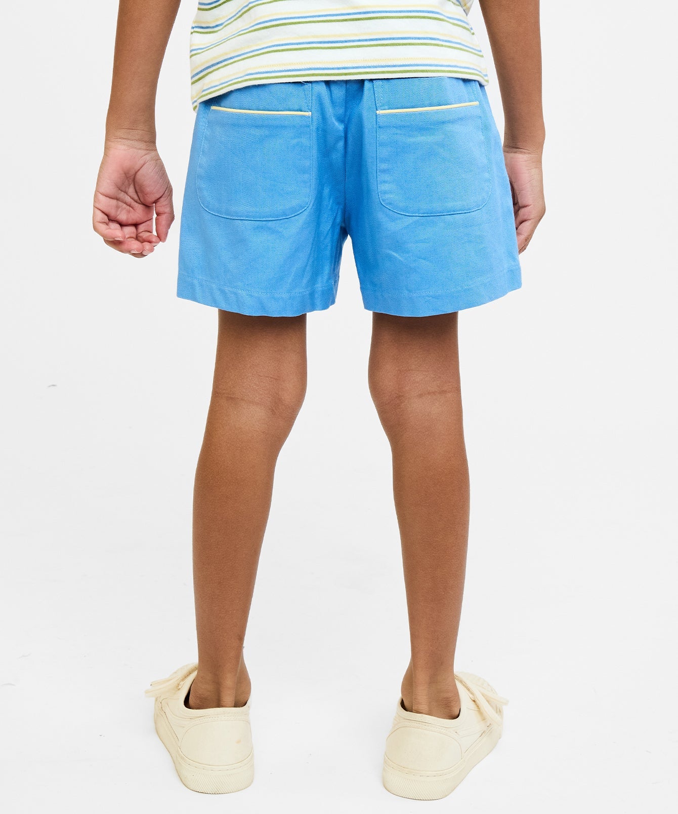 Person wearing blue shorts on a plain background